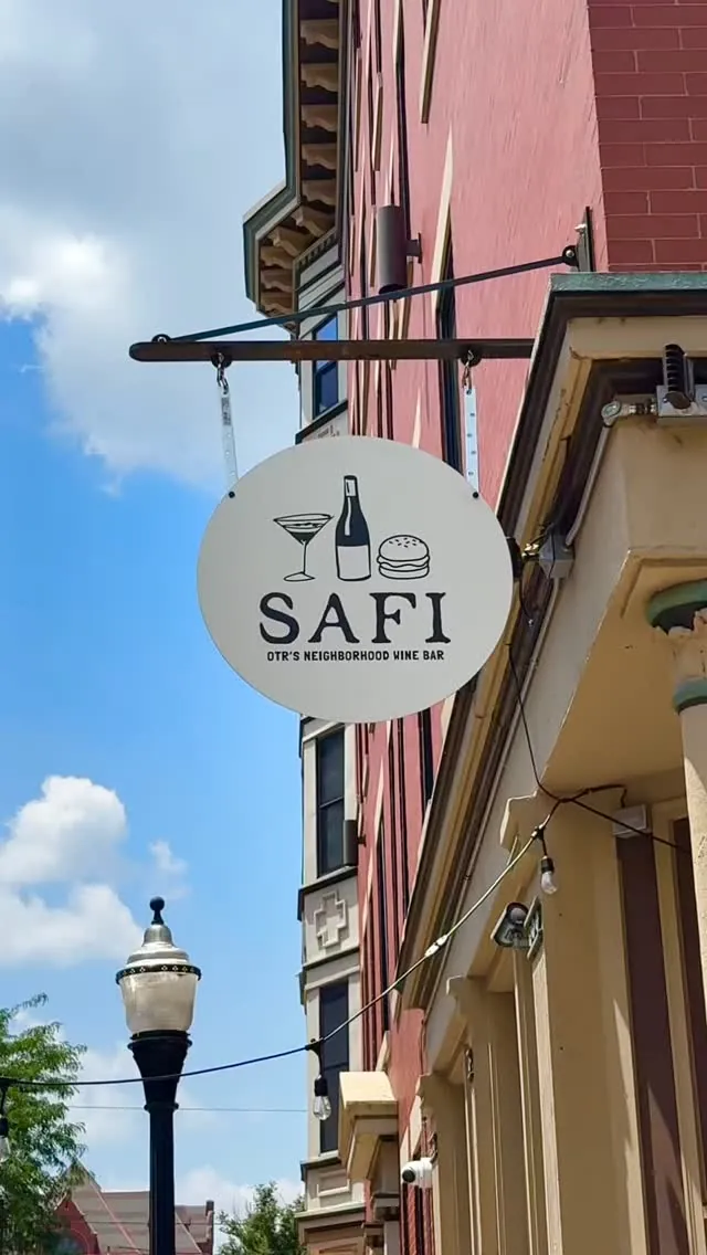 Safi's round hanging sign on the brick building at 1401 Republic Street