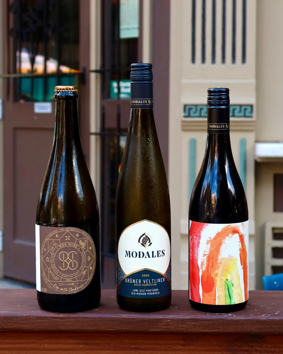 Three bottles lined up on a sunny window ledge