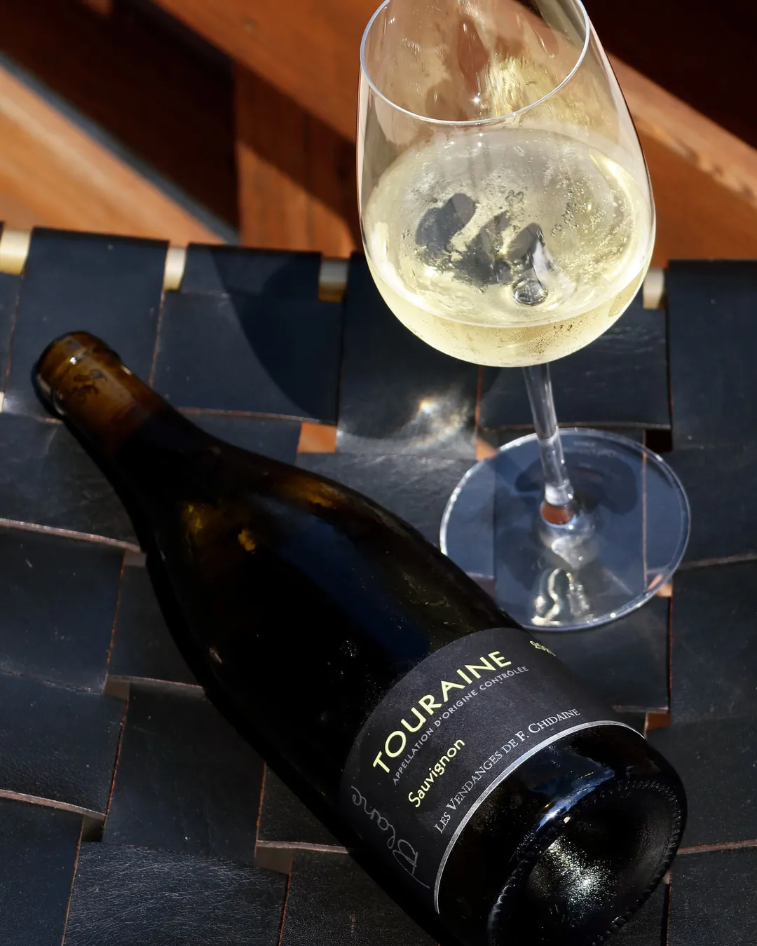 A bottle of Touraine beside a glass of white wine