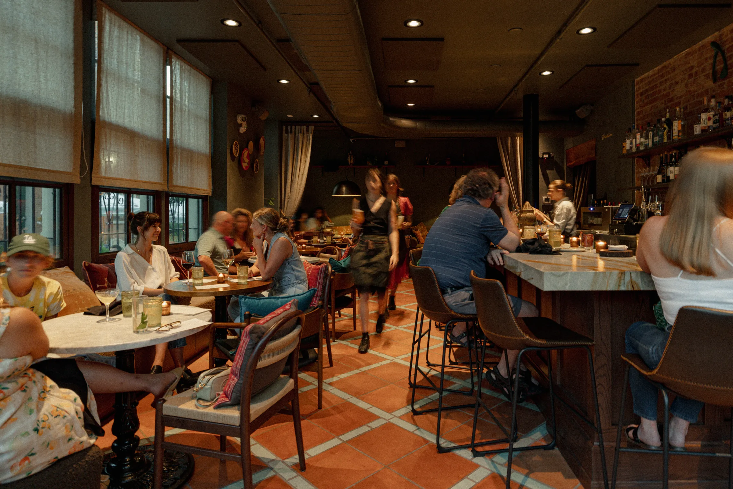 Guests at the bar and window tables inside Safi on a busy night