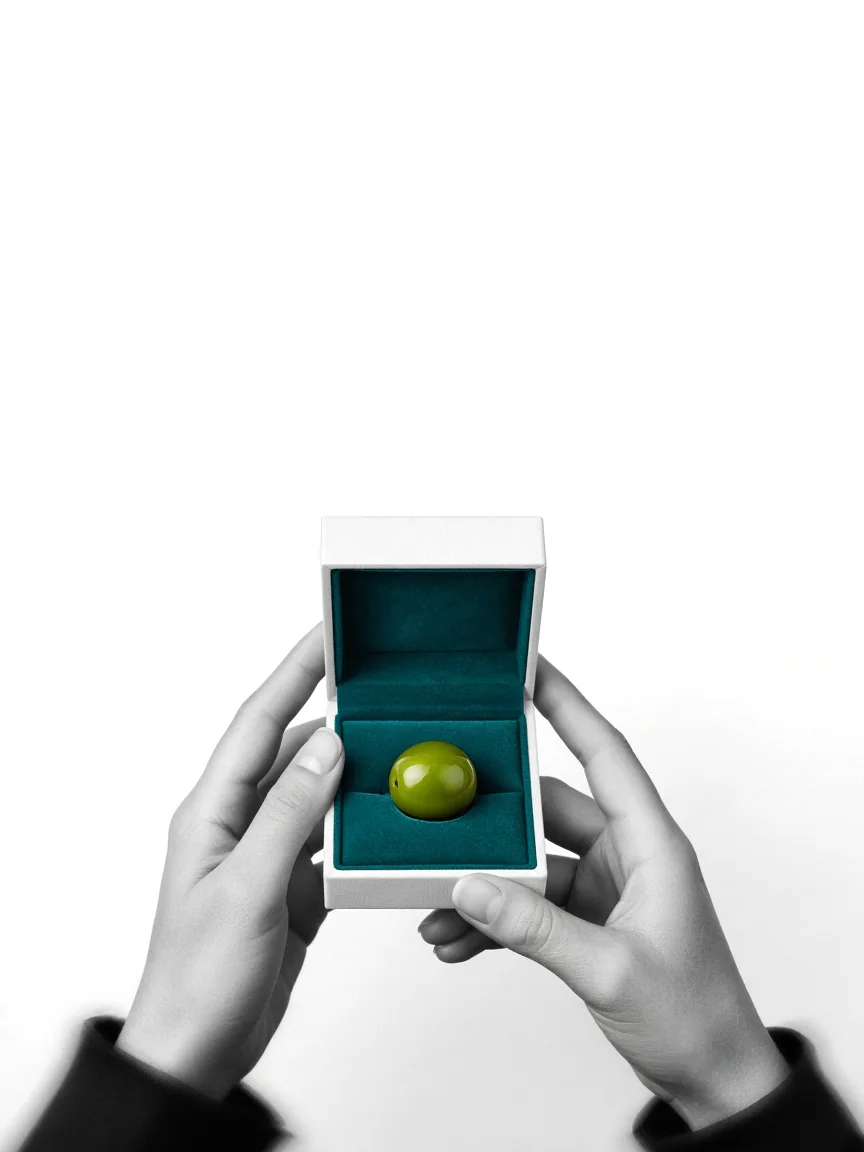 An olive presented in a teal ring box